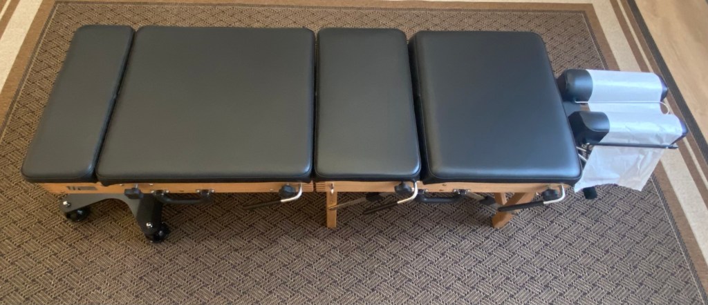 Black chiropractic adjusting table with drop technique pieces